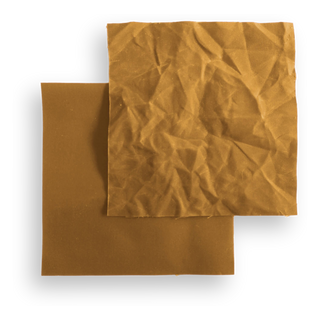 Two swatches of mustard waxed canvas, one lying flat and one crumpled to show the wax crackle.