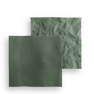 Two swatches of sage green waxed canvas, one lying flat and one crumpled to show the wax crackle.